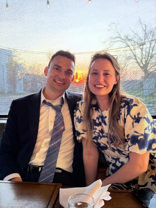 Michal and Austin seated at dinner, dressed up