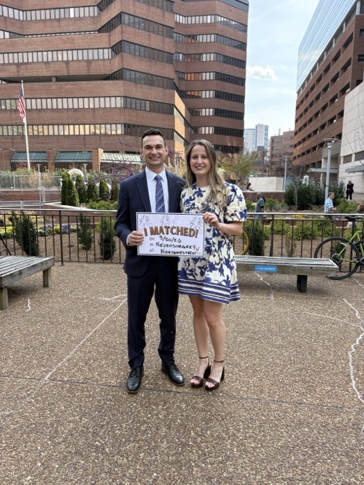 Michal and Austin outside with a match day sign